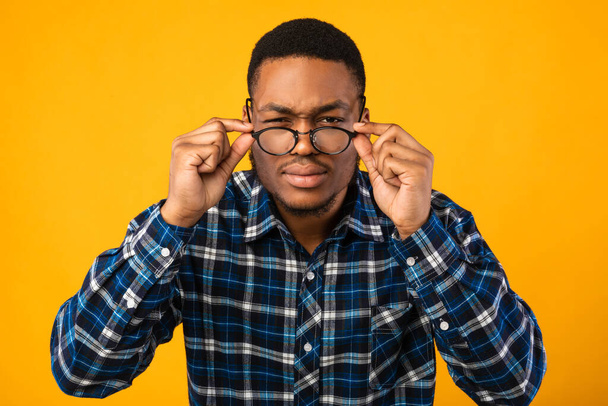 Man In Eyeglasses Looking At Camera Squinting Eyes, Yellow Background - Photo, Image