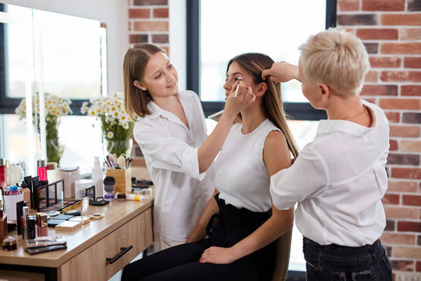 make-up καλλιτέχνης και στυλίστας μαλλιών συνεργάζονται στο σαλόνι ομορφιάς - Φωτογραφία, εικόνα