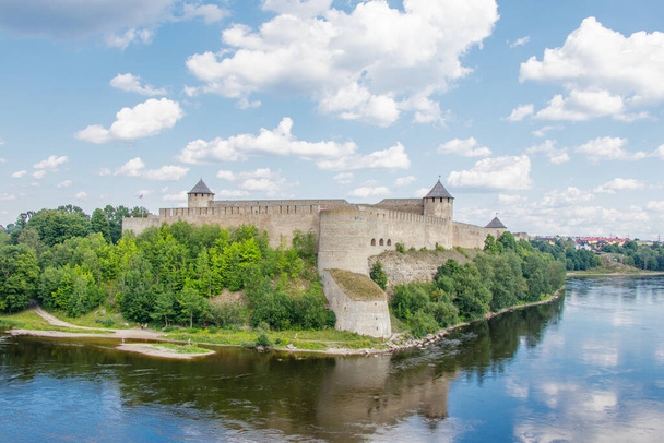 Ивангородская крепость на берегу реки Нарвы в летний полдень. Пейзаж - Фото, изображение