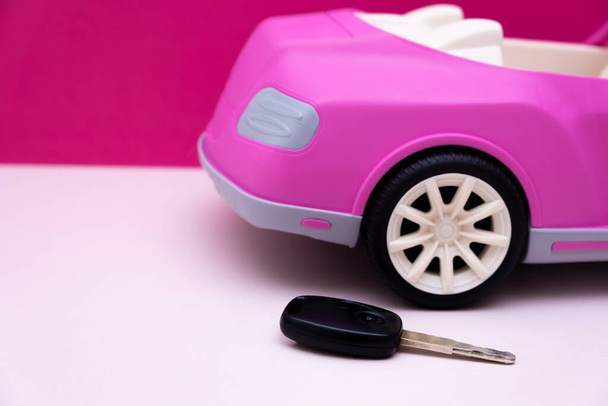Κλειδιά αυτοκινήτου και παραλλαγή ροζ αυτοκινήτου. Έννοια της πώλησης αυτοκινήτων, ενοικίαση αυτοκινήτου. - Φωτογραφία, εικόνα