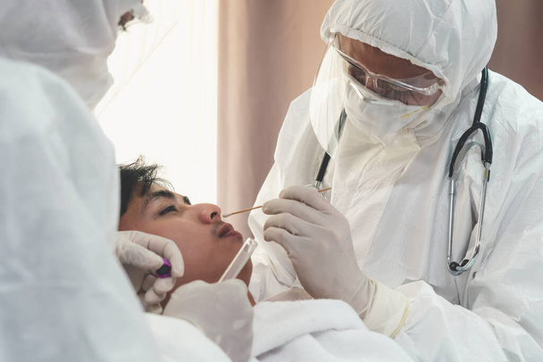 Lääkäri saada nenänielun Swab näyte testata covid 19 tai koronavirus infektio potilaalta. Covid-19 lääkärintarkastuksen henkilöstön palvelukonsepti . - Valokuva, kuva