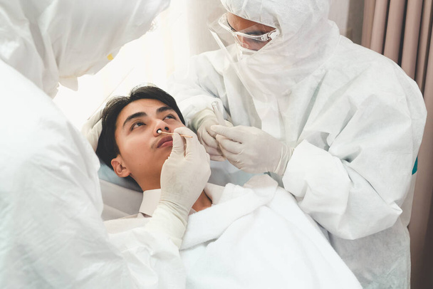 Ο γιατρός λαμβάνει Nasopharyngeal Swab Δείγμα για να εξετάσει covid 19 ή λοίμωξη από τον ιό του στομίου από τον ασθενή. Covid-19 ιατρική εξέταση έννοια υπηρεσία προσωπικού . - Φωτογραφία, εικόνα