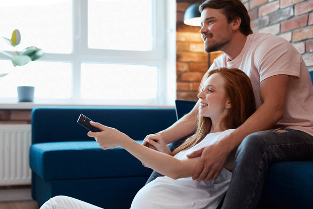 young married couple watch tv together at home - Photo, Image