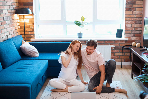 young married couple have rest using laptop on the floor - Foto, immagini