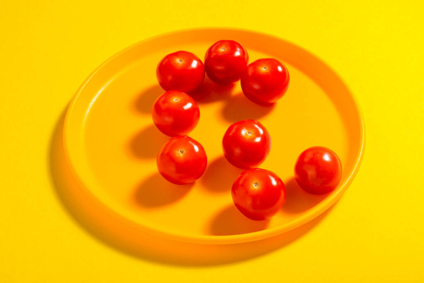 Tomate cherry en plato amarillo. Concepto. Hortalizas. Sombra. - Foto, imagen
