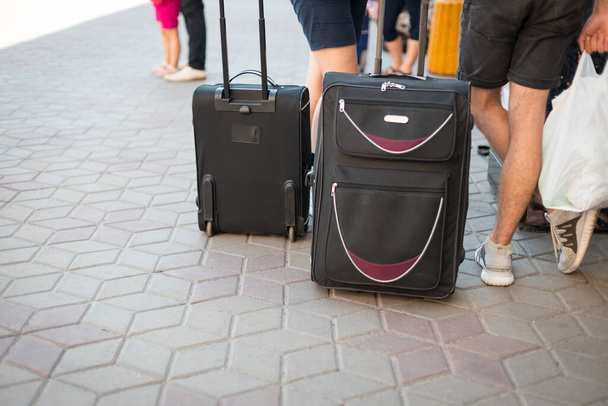 Male legs with two black suitcases at the train station station waiting for the train in the summer - Φωτογραφία, εικόνα