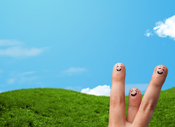 Fröhliche Finger-Smileys mit Landschaft im Hintergrund - Foto, Bild