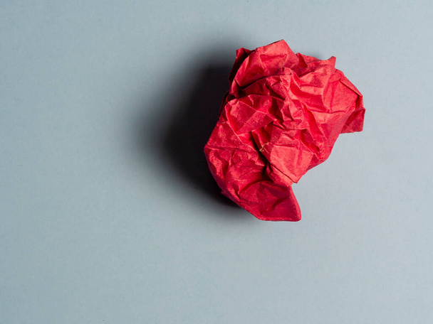 a ball of crumpled red paper on a light background. - Foto, Bild