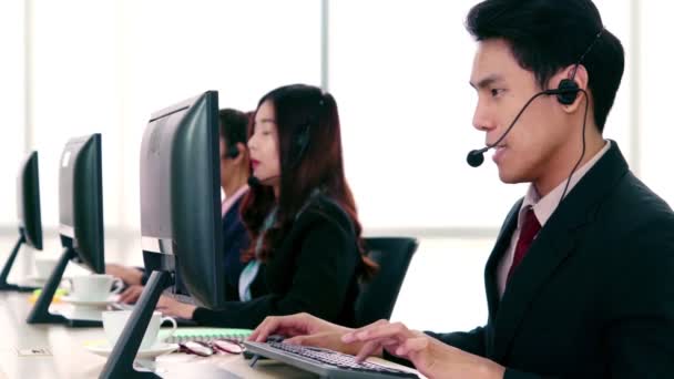 Uomini d'affari che indossano cuffie che lavorano in ufficio - Filmati, video