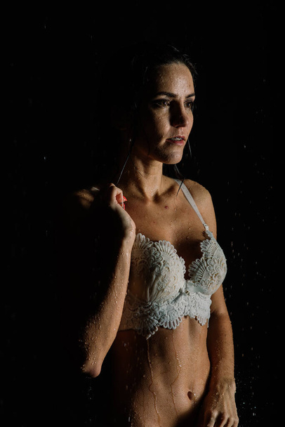 Молодая женщина с телом ущелья в белом нижнем белье с капельками воды в Aquastudio - Фото, изображение