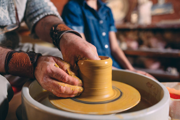 Pottery workshop. Grandpa teaches granddaughter pottery. Clay modeling - Foto, Imagem