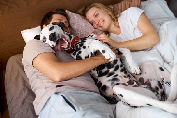 beautiful family spend weekends with dog in cozy home environment - Foto, afbeelding