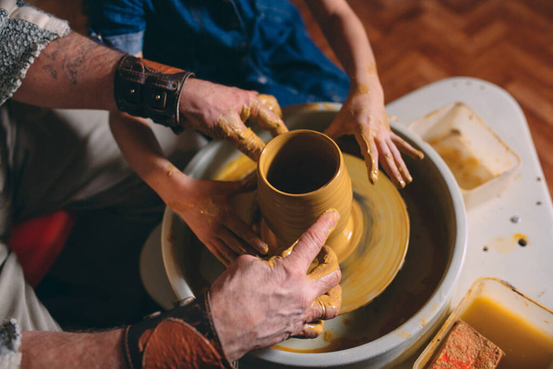 Taller de cerámica. El abuelo enseña cerámica a su nieta. Modelado de arcilla - Foto, imagen