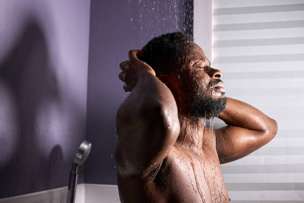 jóképű meztelen fekete férfi vesz zuhany - Fotó, kép