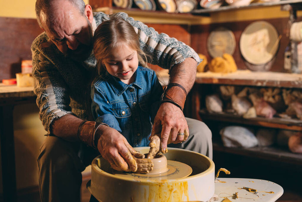 Pottery workshop. Grandpa teaches granddaughter pottery. Clay modeling - Foto, Imagem