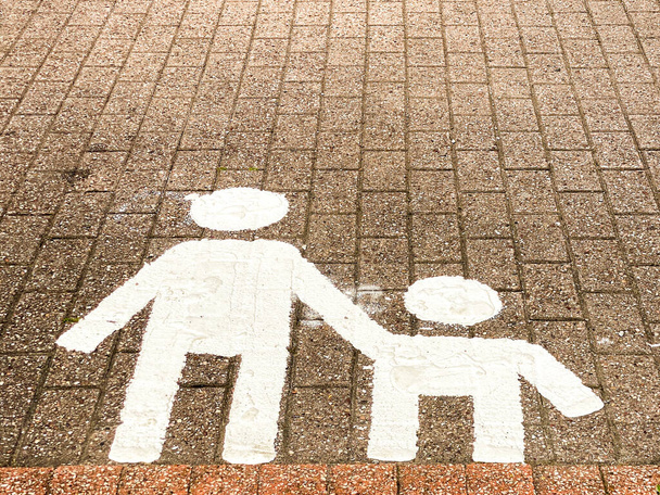 Moeder en kind symbolen geschilderd op de grond om een gereserveerde parkeerplaats te markeren - Foto, afbeelding