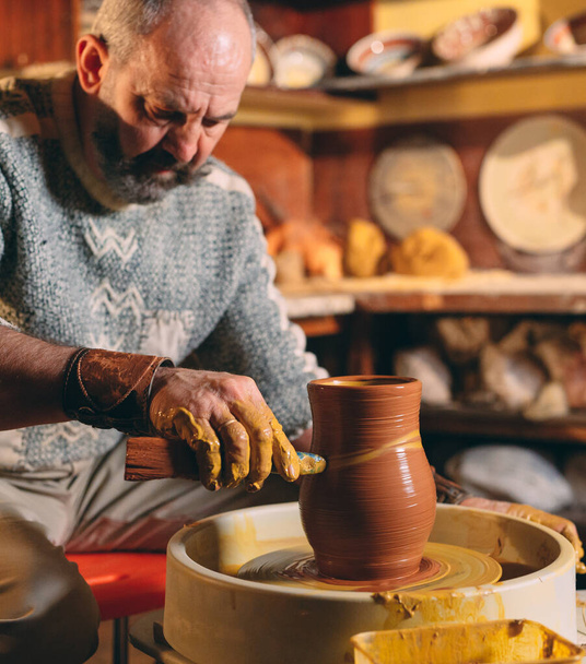 Pottery workshop. A senior man makes a vase of clay. Clay modeling - Foto, Imagen