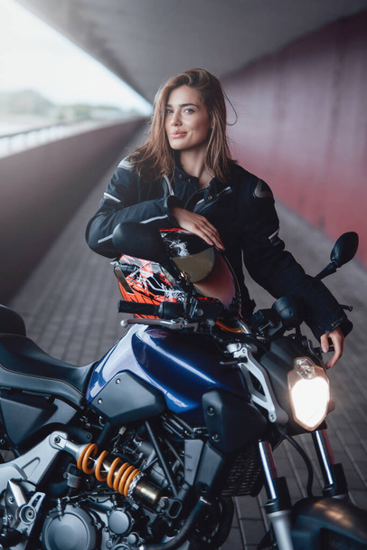 Kahverengi saçlı, modern motorsikletli kadın motorcu. - Fotoğraf, Görsel