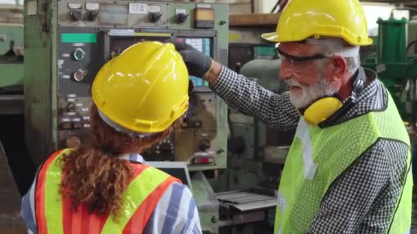 Groep fabrieksarbeiders die machineapparatuur gebruiken in fabriekswerkplaats - Video