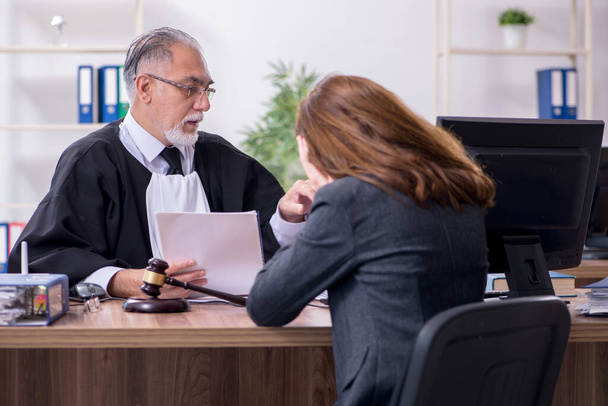 Velho juiz masculino e cliente feminino no escritório
 - Foto, Imagem