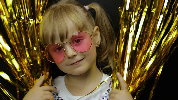 Boldog gyermek fényes fólia rojtos arany függönyben. Kis szőke lány. - Fotó, kép