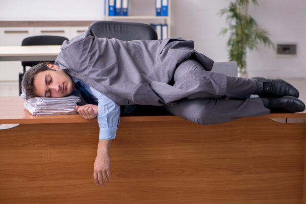 Joven empleado masculino durmiendo en la oficina - Foto, imagen
