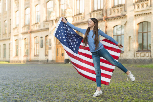 Little girl with american flag outdoors architecture background, museum national history concept - 写真・画像