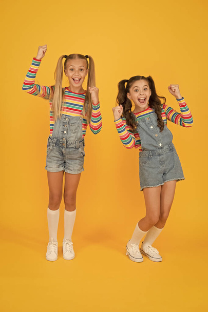 Matching outfits. Fashion shop. Must have accessory. Vibrant colors. Modern fashion. Kids fashion. Girls long hair. Cute children same outfits. Trendy and fancy. Little girls wearing rainbow clothes - Foto, imagen