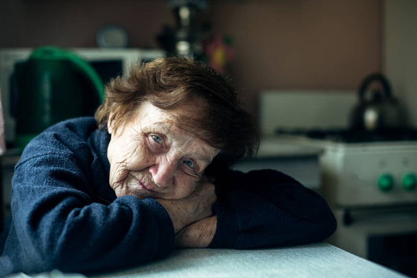 Una donna anziana è triste nella cucina di casa sua. - Foto, immagini