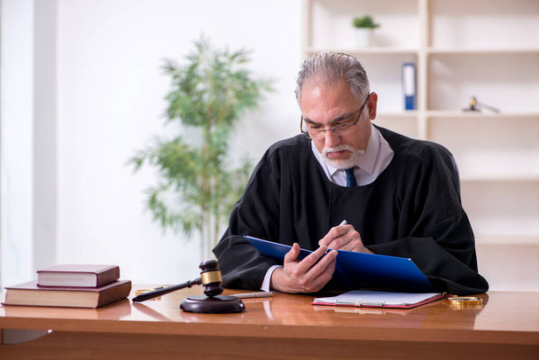 Oude mannelijke rechter werkt in het gerechtsgebouw - Foto, afbeelding