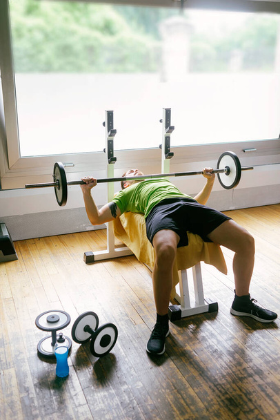 Bearded guy lifting weights at the gym - Valokuva, kuva