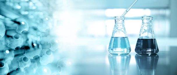 Zwei Glaskolben mit Tropfer und Molekularchemie auf blauem Laborhintergrund - Foto, Bild