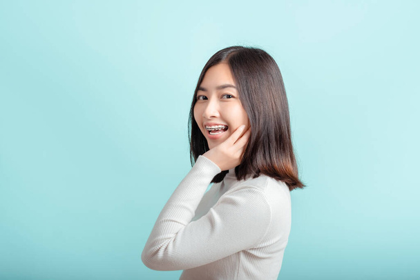 Dental braces of young asian woman wearing braces beauty smile with white teeth increase confidence for healthy on blue background isolated studio shot, Happiness teenager smiling facial expression. - Foto, Bild