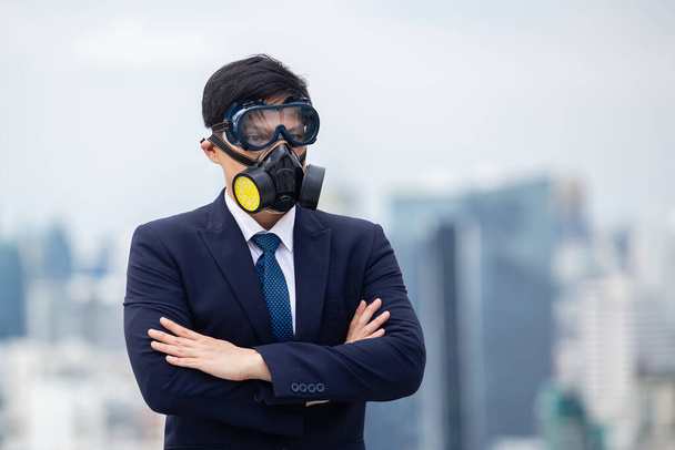 Азиатские бизнесмены скрещивают руки в пыли и химической маске. - Фото, изображение