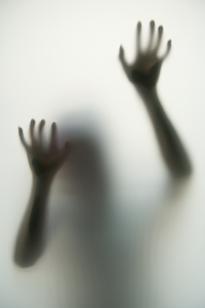 Temný stín rukou a těla za neprůhledným sklem to v halloweenském pojetí dělá děsivým.. - Fotografie, Obrázek