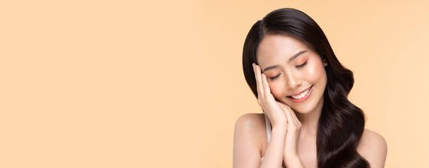 banner of Beautiful Young Asian Woman Holding Hands Close her eyes smile feeling so happy and cheerful with healthy Clean and Fresh skin,isolated on Beige background,Beauty Cosmetic Concept - 写真・画像
