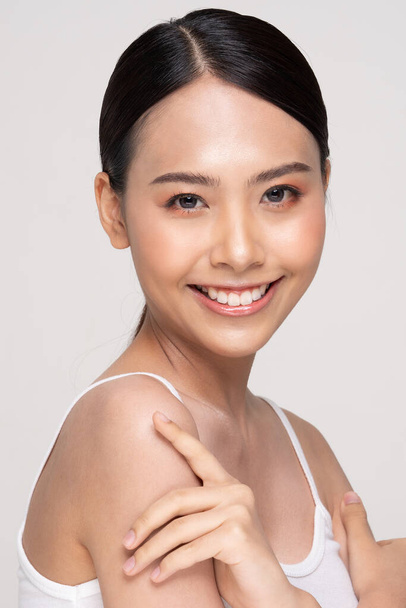 Beautiful Young Asian Woman Looking While Touching Shoulder feeling so happy and cheerful with healthy Clean and Fresh skin,isolated on white background,Beauty Cosmetics Concept - Φωτογραφία, εικόνα