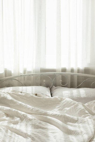 寝室の美しい朝の光。パステルカラーの白い寝具。流行の有機天然リネンの寝具。居心地の良い家のインテリア. - 写真・画像