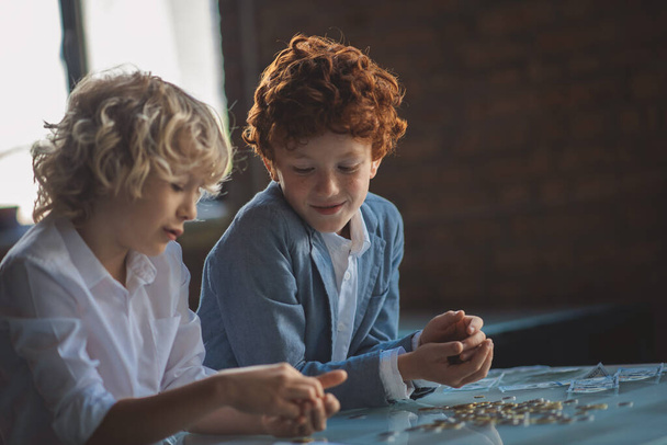 Two boys counting coins and looking busy - Foto, Bild
