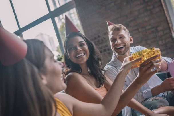 Trois amis souriants buvant de l'alcool pendant la fête d'anniversaire - Photo, image