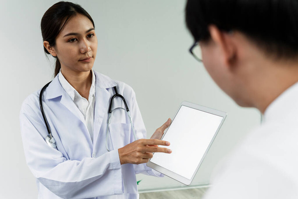 Жінка-лікар показує лабораторний результат таблетки для її пацієнта чоловічої статі
. - Фото, зображення