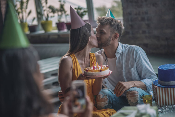 Couple kissing each other at the birthday party - Foto, Imagen