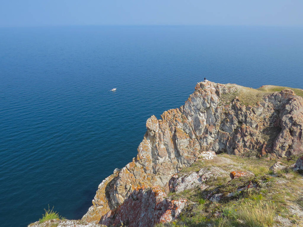 Turysta na szczycie klifu na wyspie Olkhon. Widok na jezioro Baikal latem. - Zdjęcie, obraz