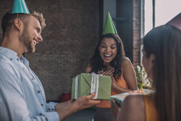Smiling woman receiving a birthday gift frim her friends - Foto, Imagem
