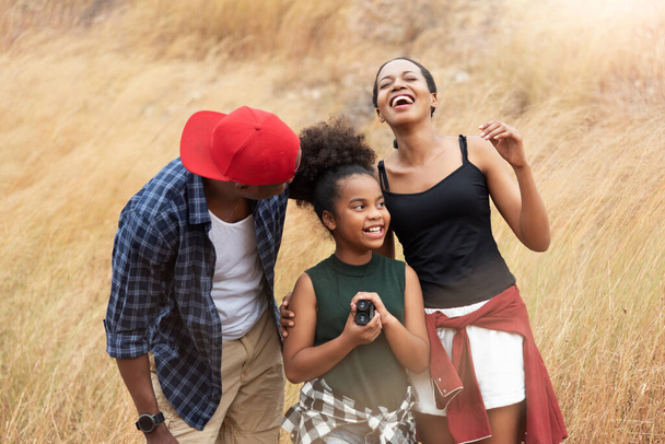 Beautiful African family having fun in autumn field outdoor, Attractive African-American man, woman and girl laughing at outside on holiday. Cheerful Father, Mother and daughter smiling together - Foto, imagen