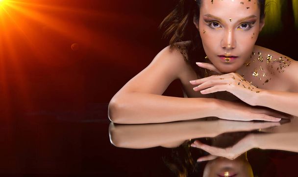 Portrét módní 20s Asijské Žena má krásné aktualizace make-up umělec na štětci, ona zdobí módní zlatý list na tváři hlavy a odrážejí zrcadlo, kopírovat prostor - Fotografie, Obrázek