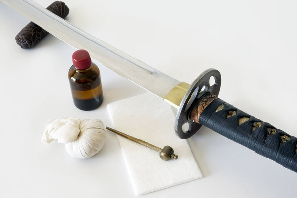 A traditional Katana sword next to special cleaning supplies - Foto, afbeelding