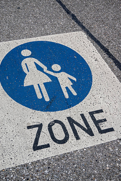 歩行者ゾーンの道路標識青を背景に少女とゾーンという言葉を持つ女性 - 写真・画像