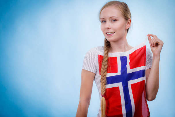 Blonde girl braid hair with norwegian flag, on blue. Scandinavian people. - Фото, изображение