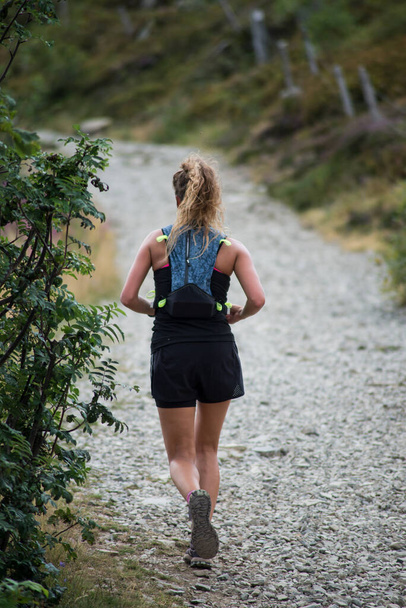 Portrait on back view of girl running in the mountain way - Foto, Imagen